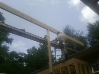 Carpenter setting a ridge beam over a new addition frame — Ice Dam Removal by Roofing Brothers in Orland