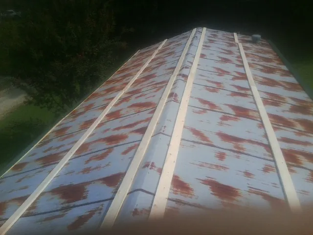 Rusted metal roof panels with new wood purlins before replacement — Storm Damage Roof Repair in Orland by Roofing Brothers
