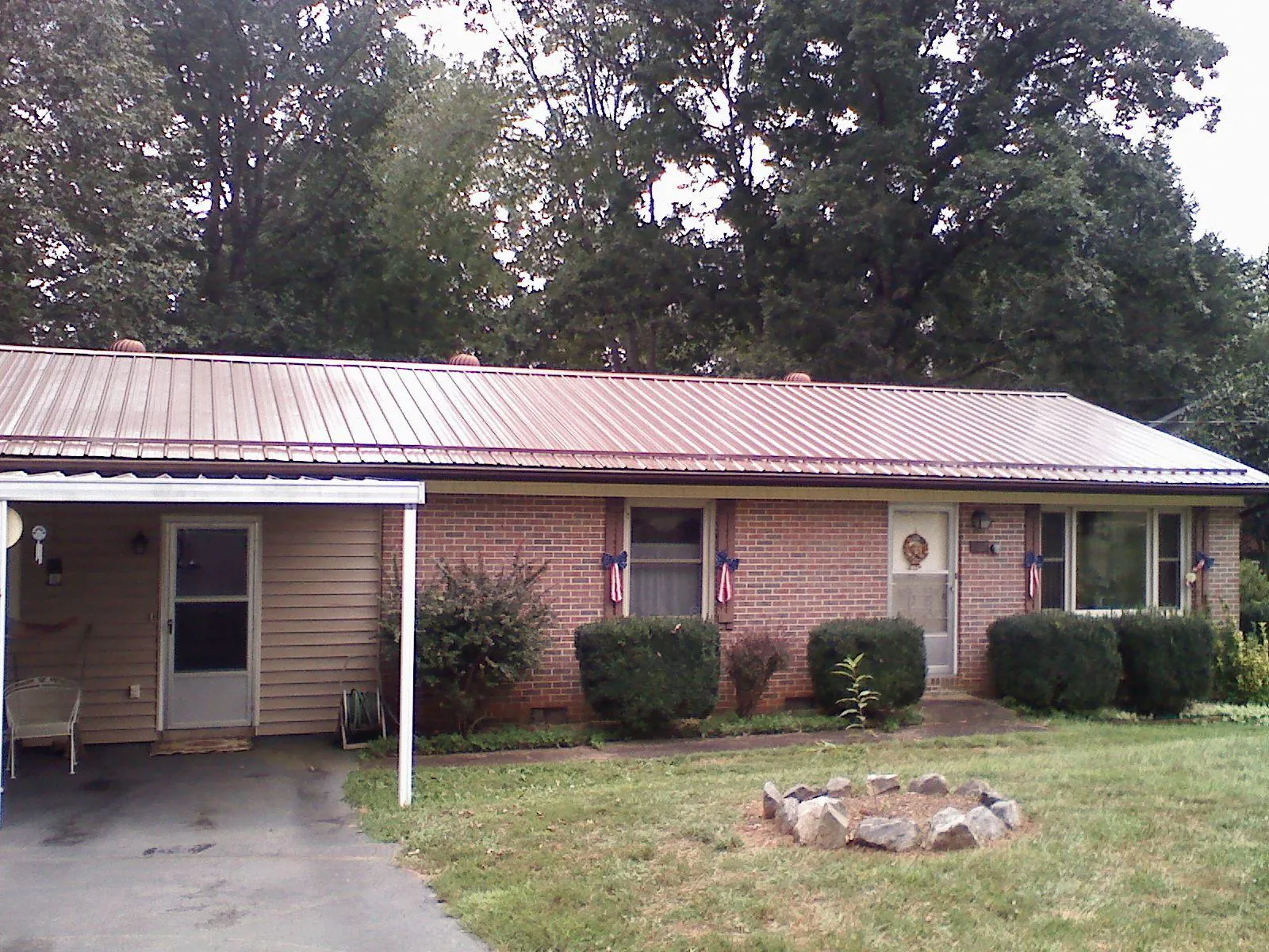Bronze metal roof and carport on a brick ranch home — Roof Repair work by our crew in Orland